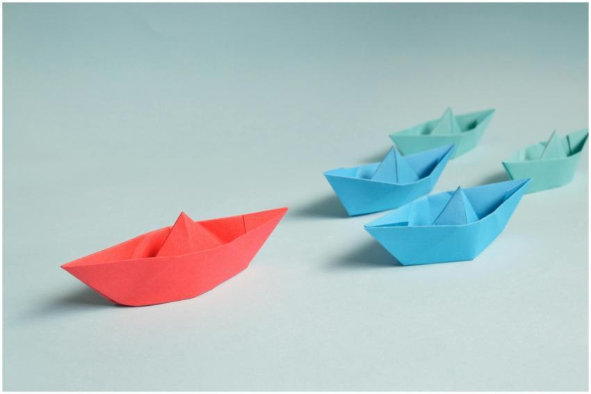 Colorful origami paper boats arranged to depict le