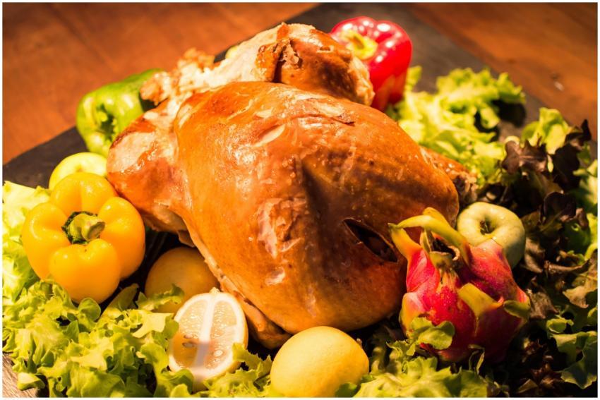 Close-up of a roasted chicken surrounded by fresh