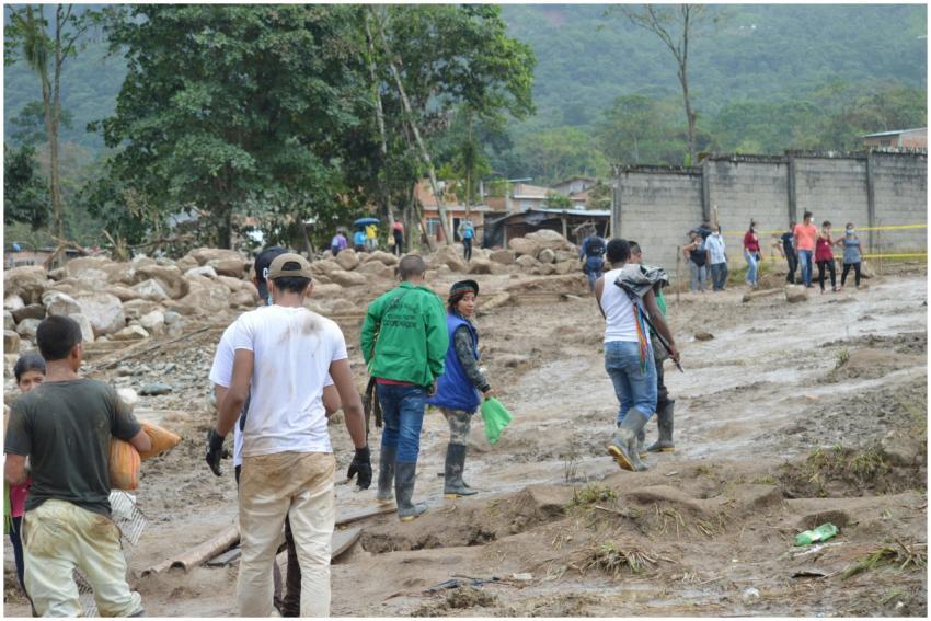 People navigate a muddy terrain in Mocoa, Colombia