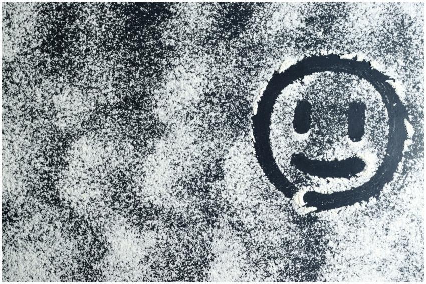 Artistic smiley face drawn through white powder on