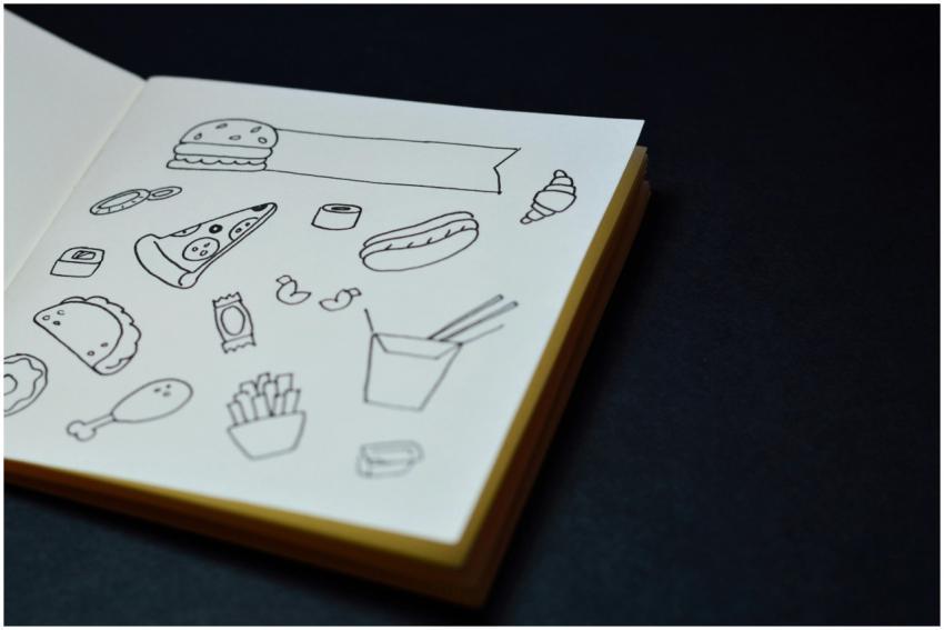 Open sketchbook displaying hand-drawn food doodles