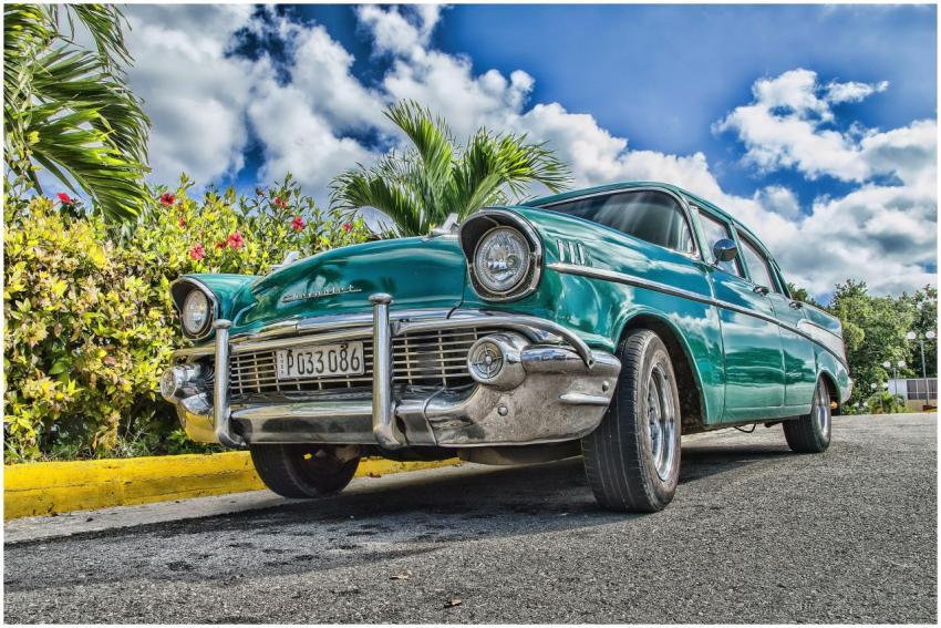 A beautifully restored classic car on a sunny road