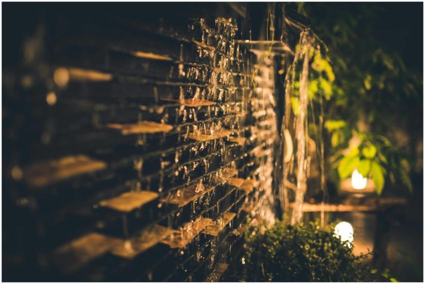 A serene and illuminated garden waterfall captured