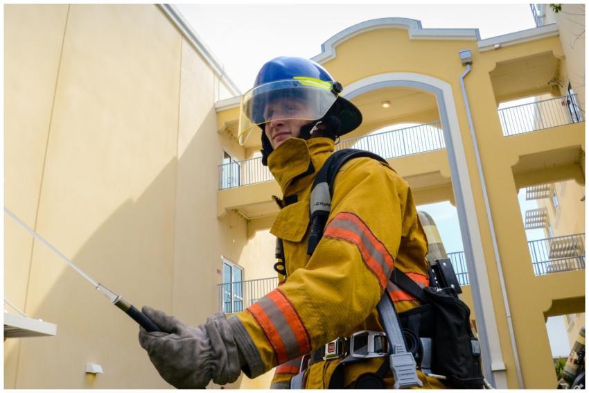 A firefighter in full protective gear operates out