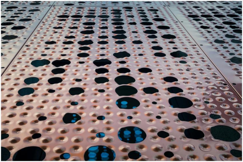 Abstract close-up of a perforated metal surface wi