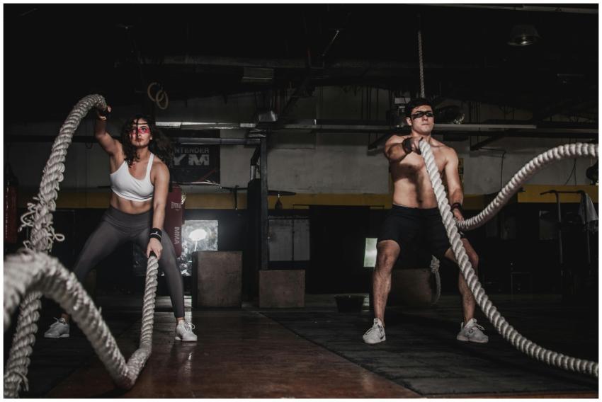 Two people engage in a powerful indoor battle rope