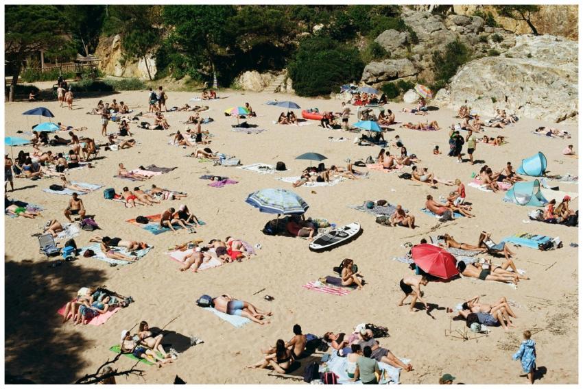 A lively summer beach filled with sunbathers and u