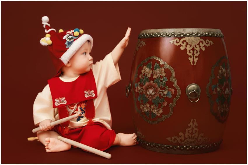 Adorable baby in Vietnamese costume playing with a