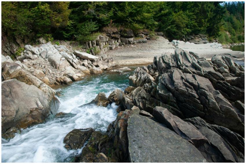 A picturesque river cascades over rocks in a lush