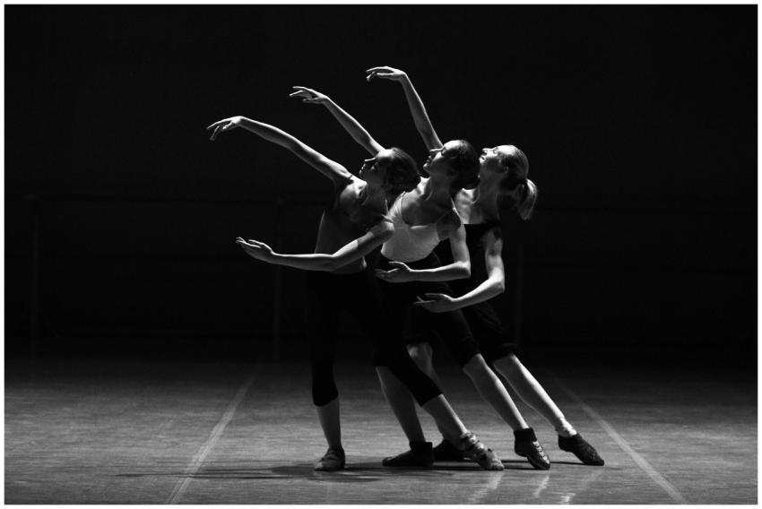 Three female ballerinas perform a synchronized dan