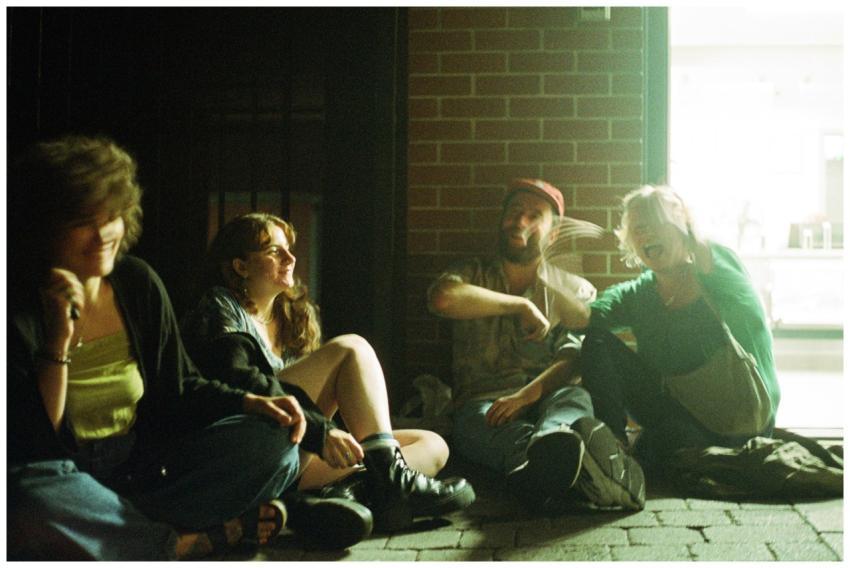 A group of friends sitting outside, enjoying a cas