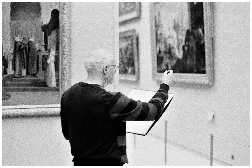 An elderly man sketching paintings in a museum, ca