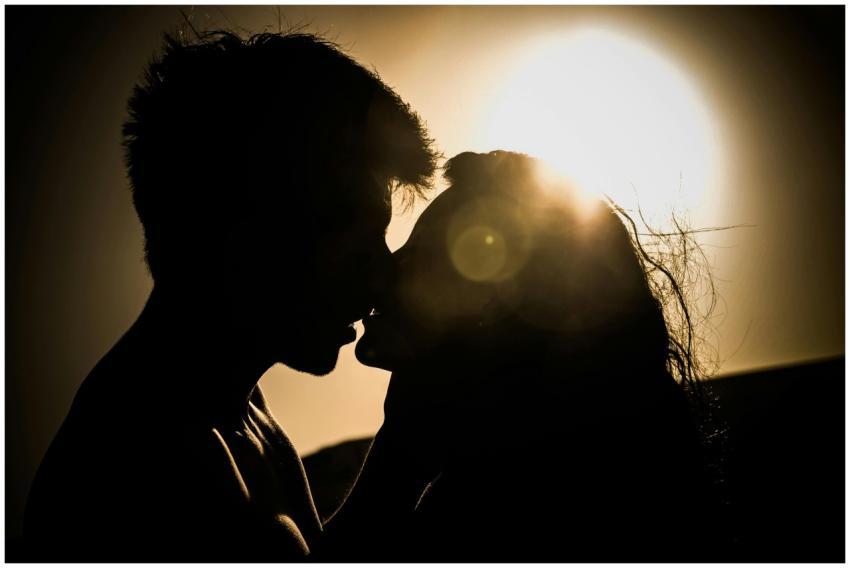 Silhouette of a couple kissing with the sun settin