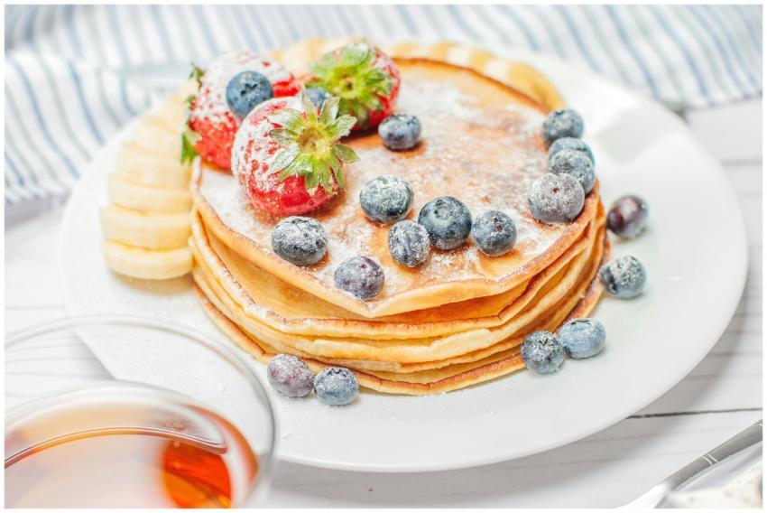 Stack of pancakes topped with fresh strawberries,