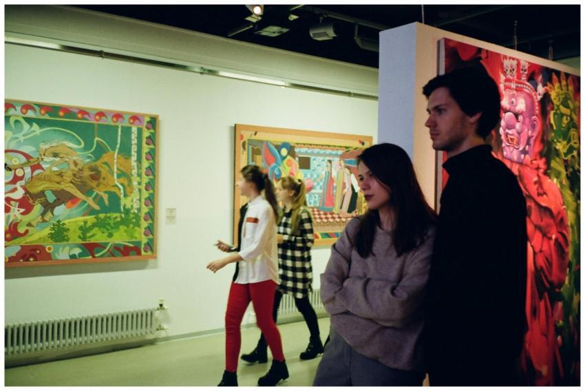Visitors engaged with vibrant art pieces in a St.