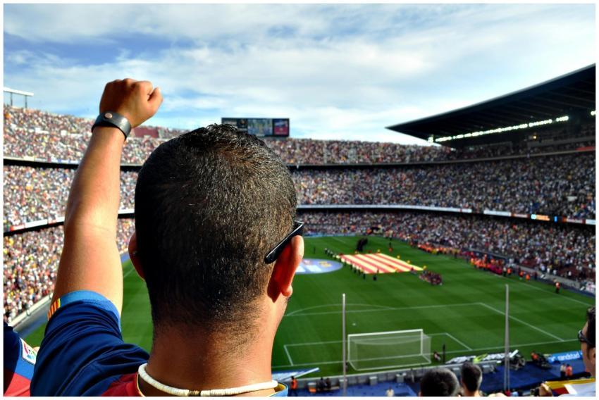 A passionate football fan cheers among a crowd at