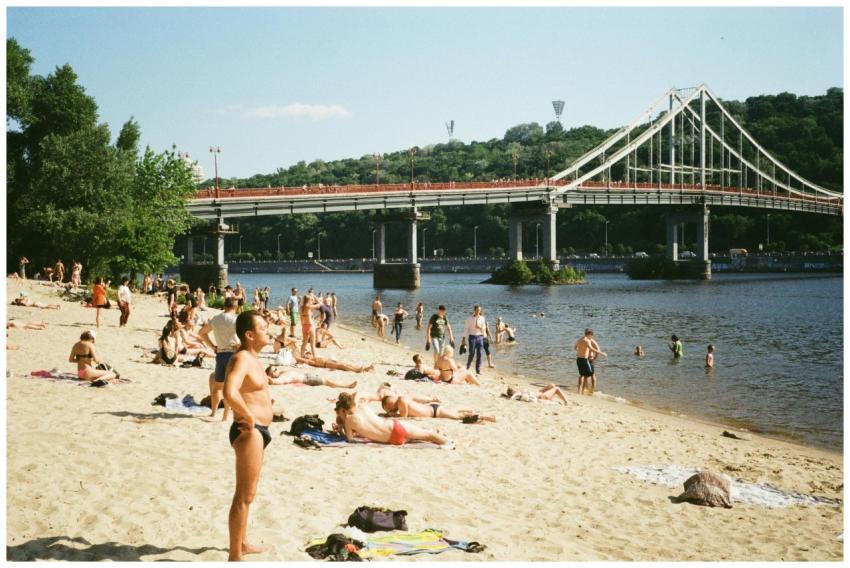 People enjoy a sunny day on the sandy beach by the