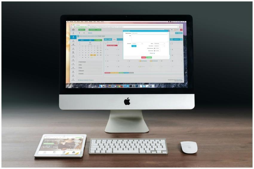 A sleek office setup featuring an Apple iMac, iPad