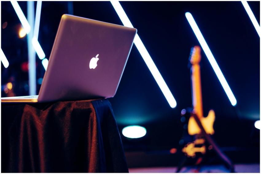 A sleek laptop sits on a table with vibrant neon l