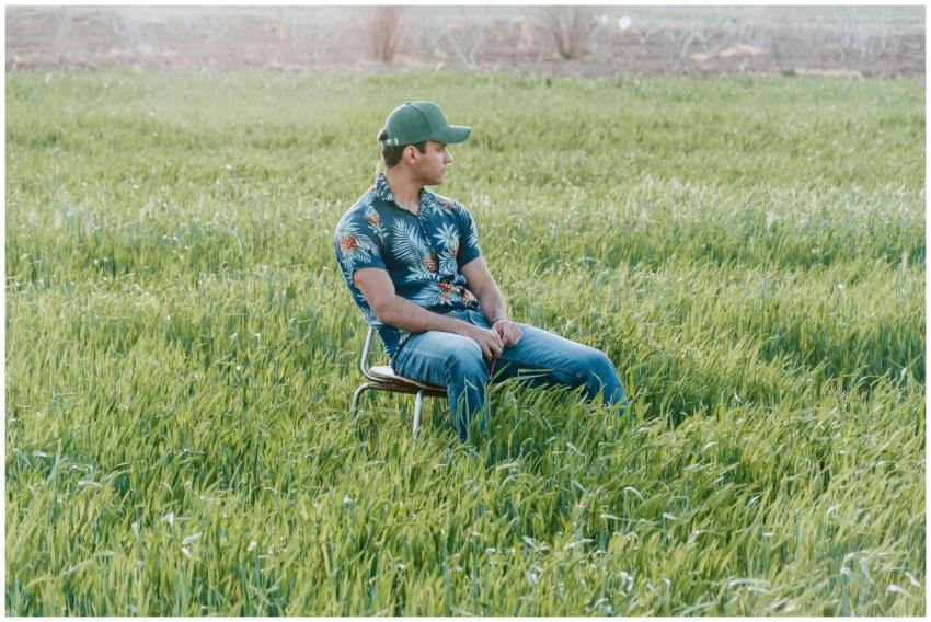 A young man in casual attire sitting on a chair in