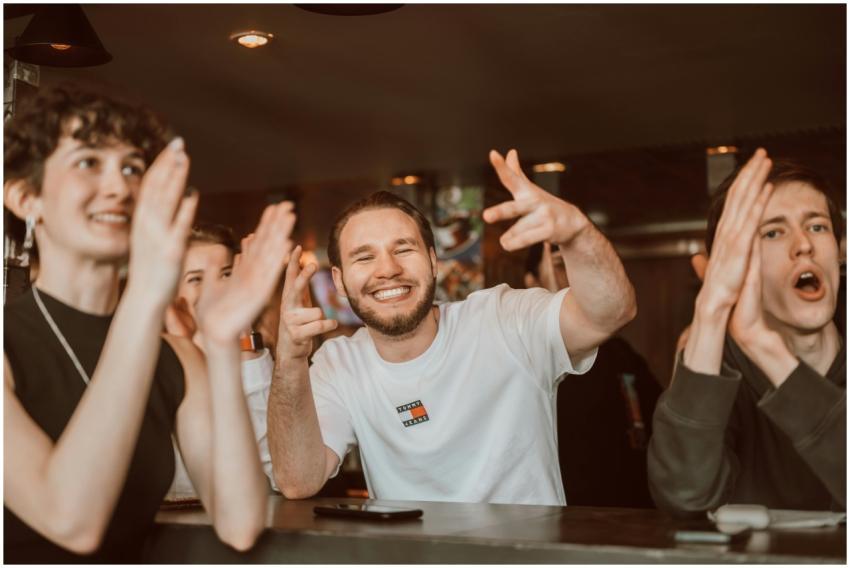 A group of adults applauding and cheering indoors