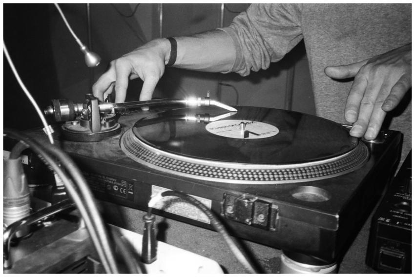 Close-up of a DJ using a turntable to play vinyl r