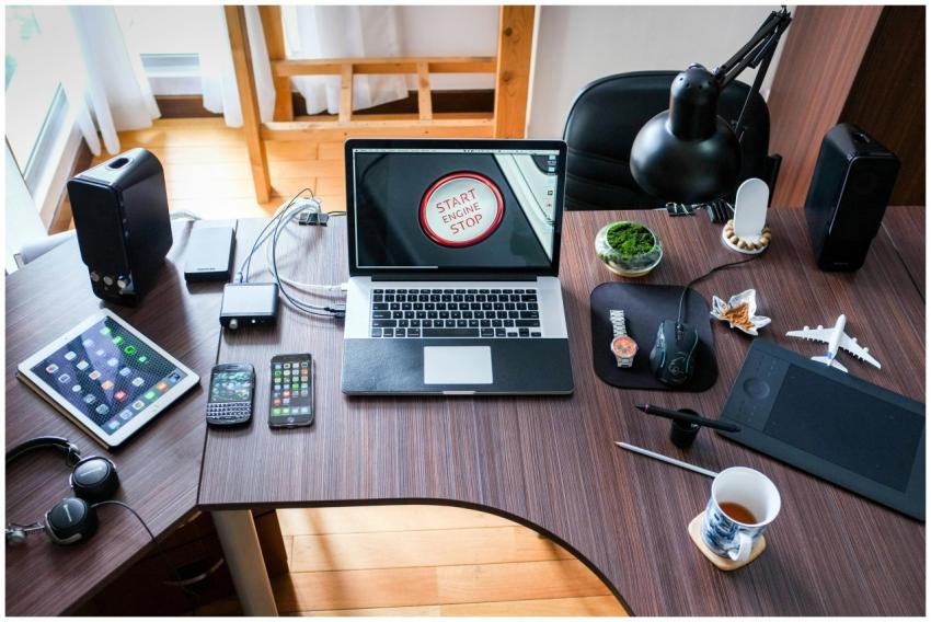 A contemporary office desk setup with laptops, gad