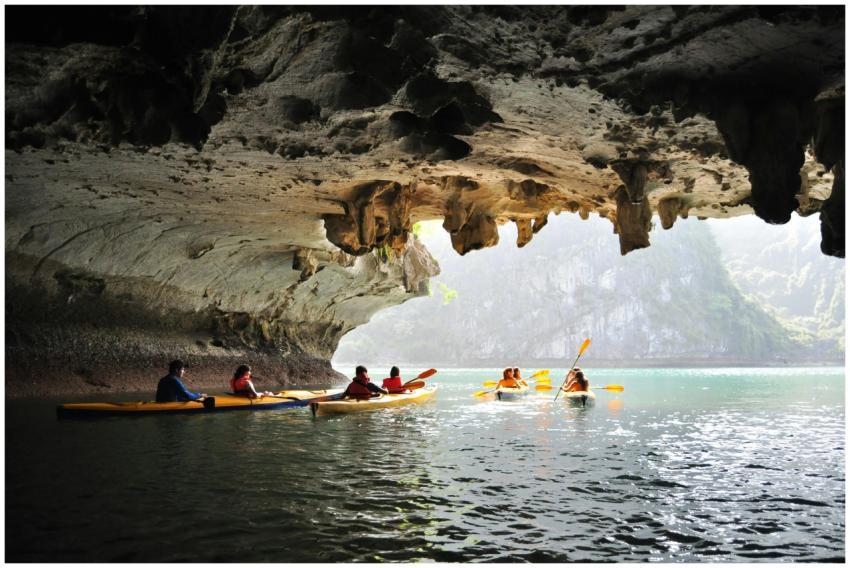 Adventure seekers kayaking inside a scenic cave wi