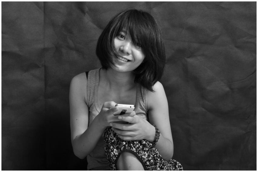 Black and white portrait of a smiling woman holdin