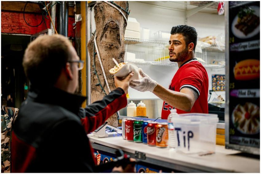 Street vendor serves food to a customer at an outd