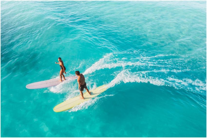 Explore surfers gliding on turquoise waves in a st