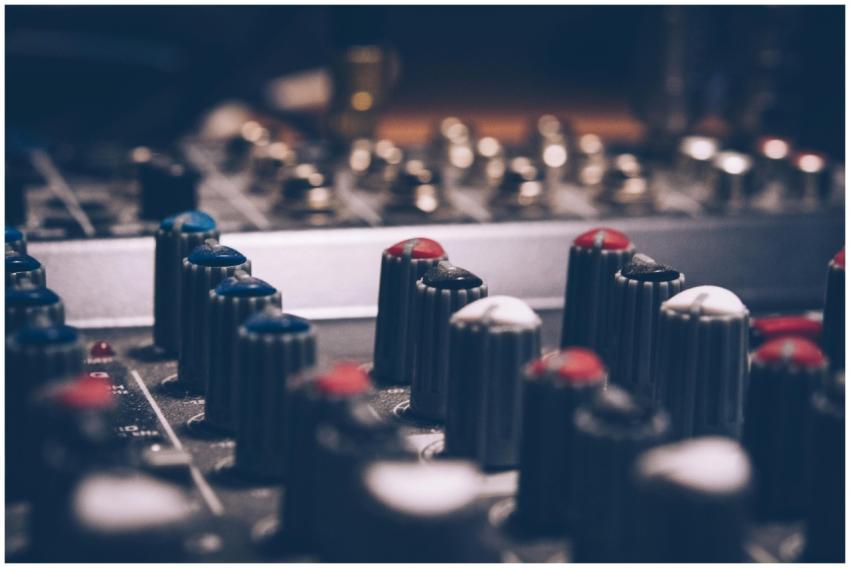 Close-up of audio mixer knobs in a dimly lit studi