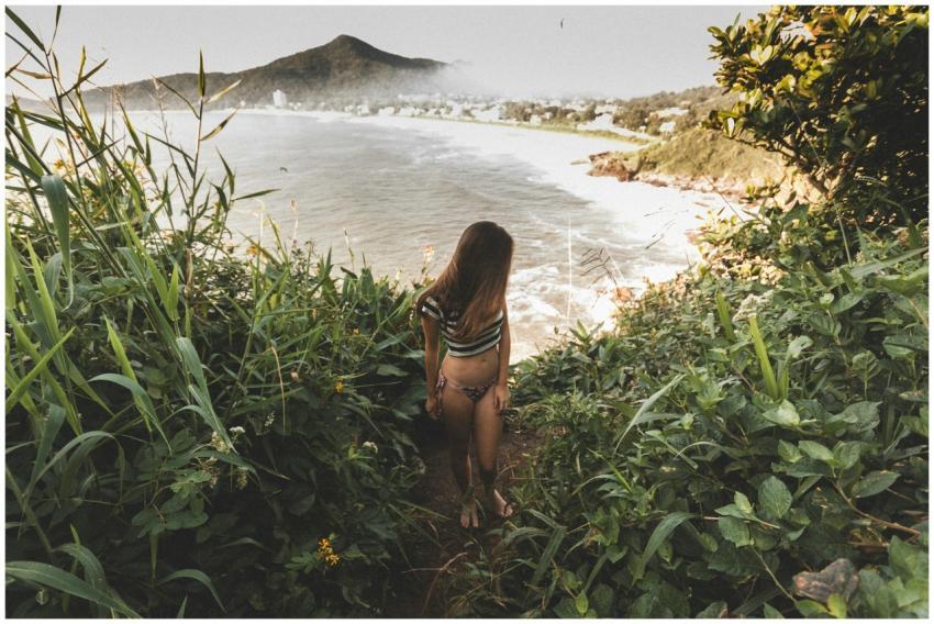 A woman in summer attire walking down a scenic pat