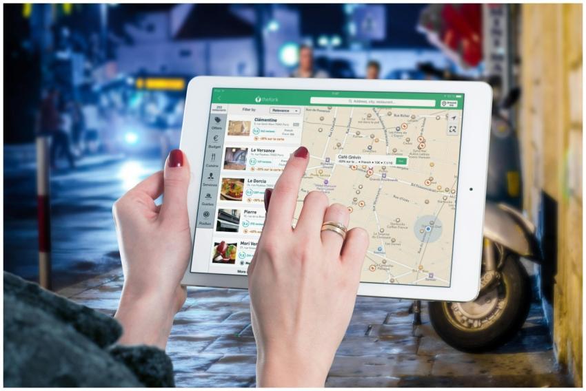 Hands using a digital map on a tablet in an urban