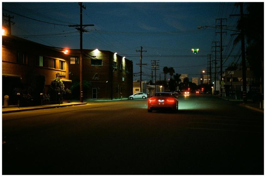 A mysterious car driving on a quiet street at nigh