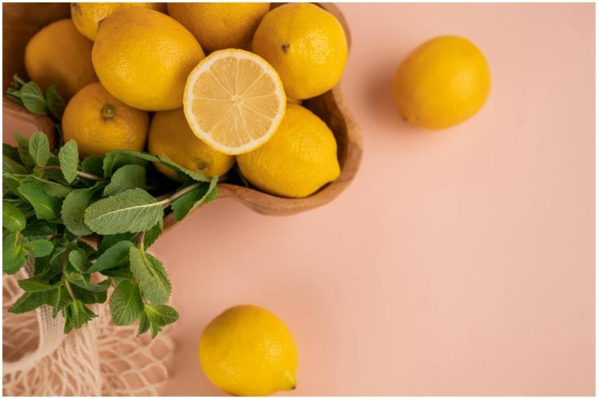 Bright and fresh lemons with mint leaves on a past
