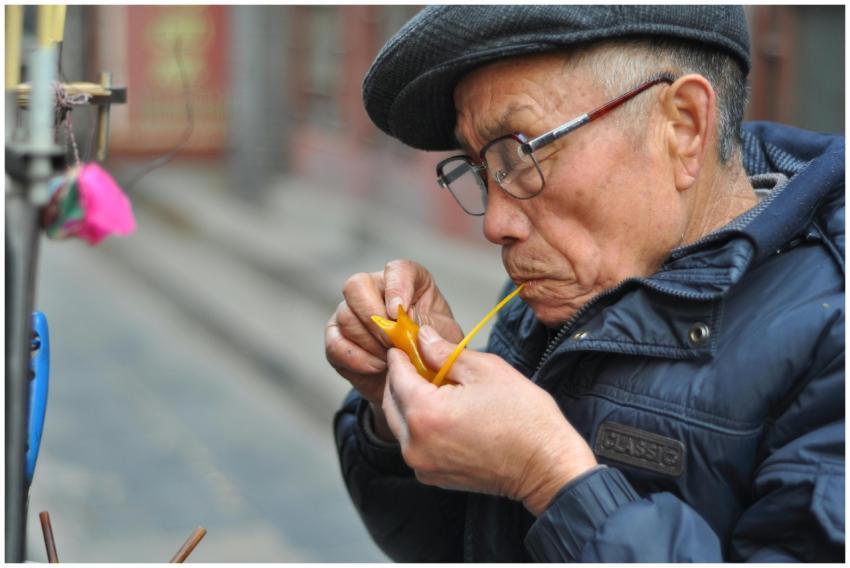 Focused elderly man using traditional crafting tec