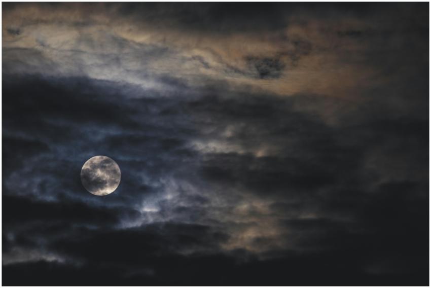 A dark, moody night sky capturing the full moon su