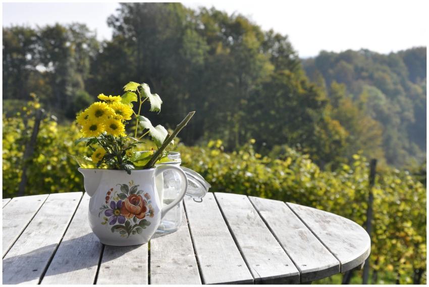 Yellow flowers in a decorative vase on a wooden ta