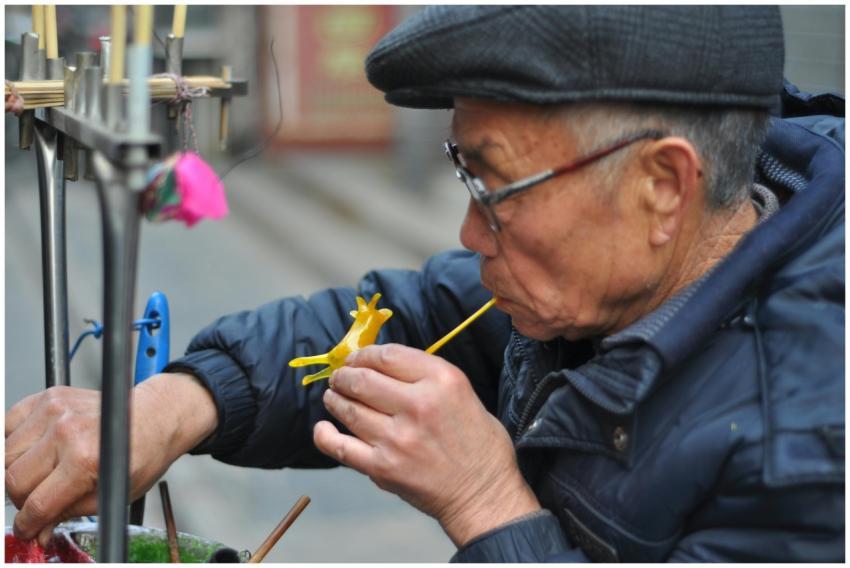 Elderly artisan shaping a detailed sugar sculpture