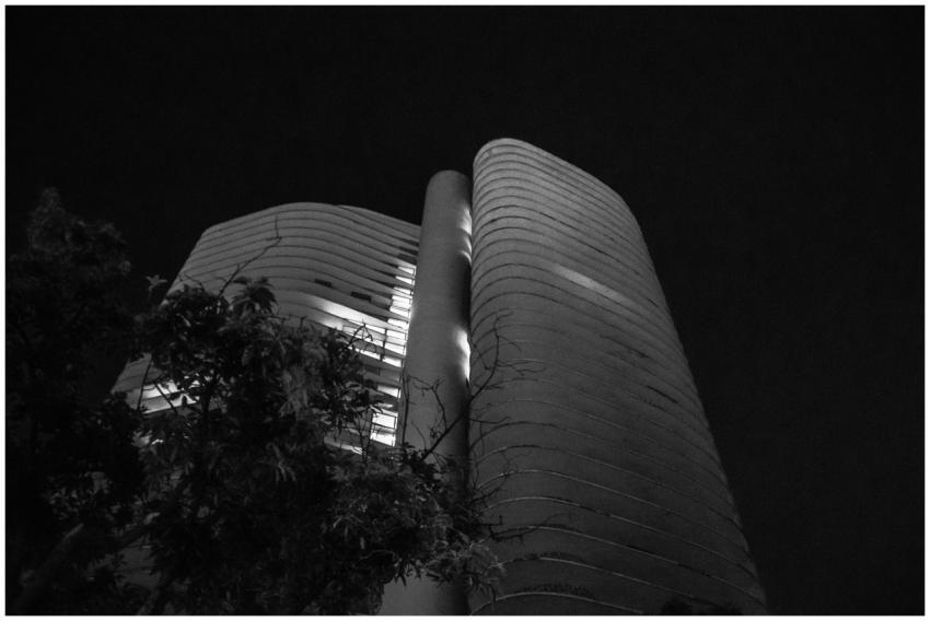 Black and white photo of a modern building at nigh
