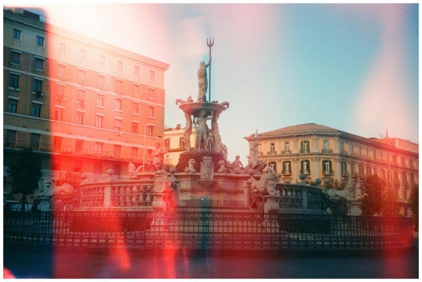 Artistic film photo of a Neptune fountain with cla