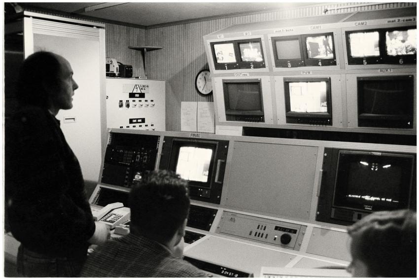 Men working in a vintage broadcasting control room