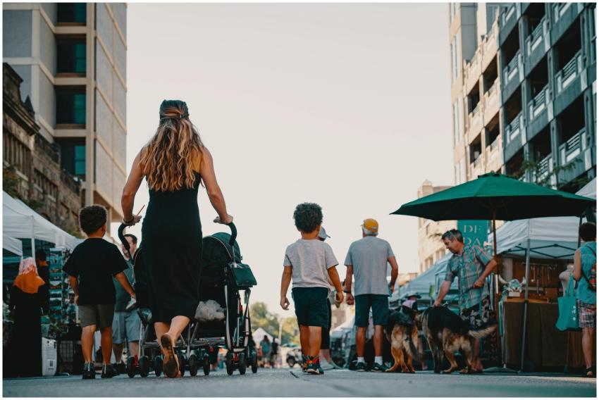 Family walking with stroller and dogs through live