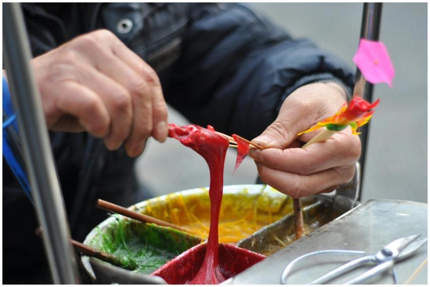 Street artist crafting colorful sugar figurines li