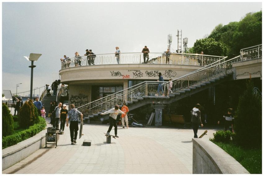 Skateboarders and pedestrians enjoy a busy urban p