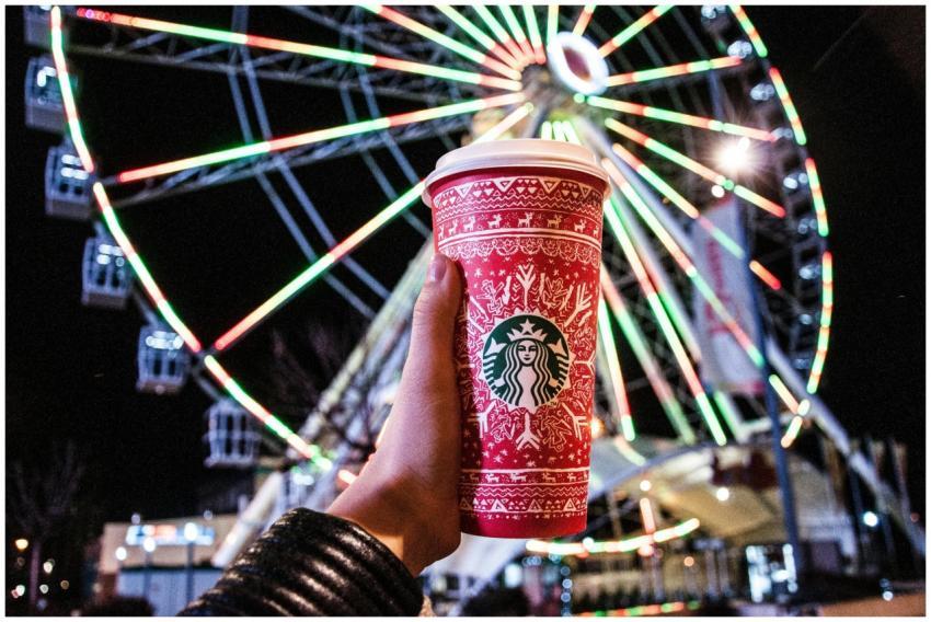 A red festive cup in hand contrasts against an ill