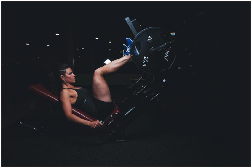 A woman engages in an intense leg press workout at