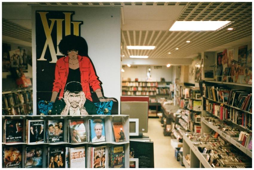 Explore a cozy bookstore with vivid comic posters