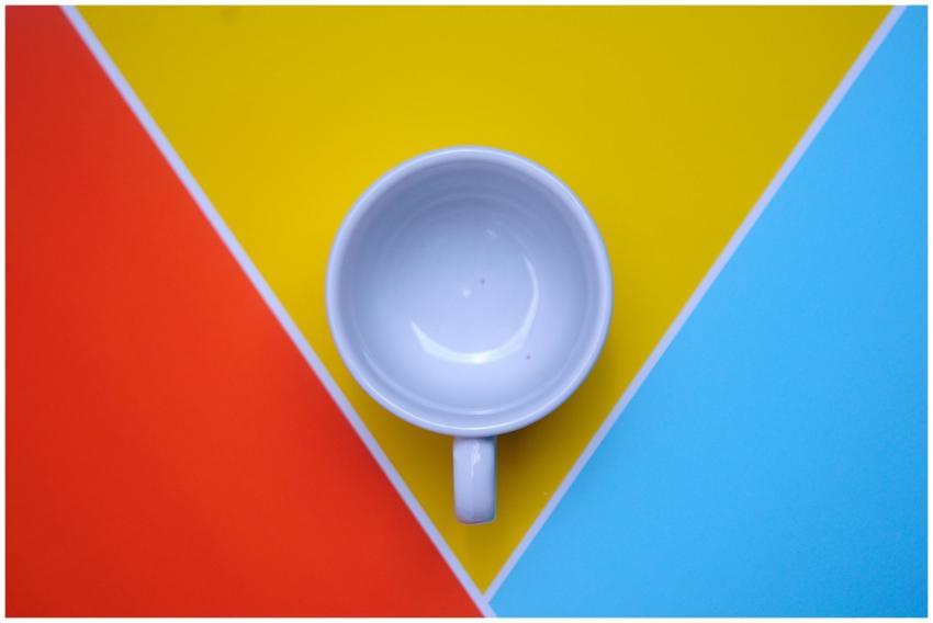 Overhead shot of a white mug on vibrant red, yello